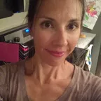 A woman in a casual indoor setting considering her nutritional choices.