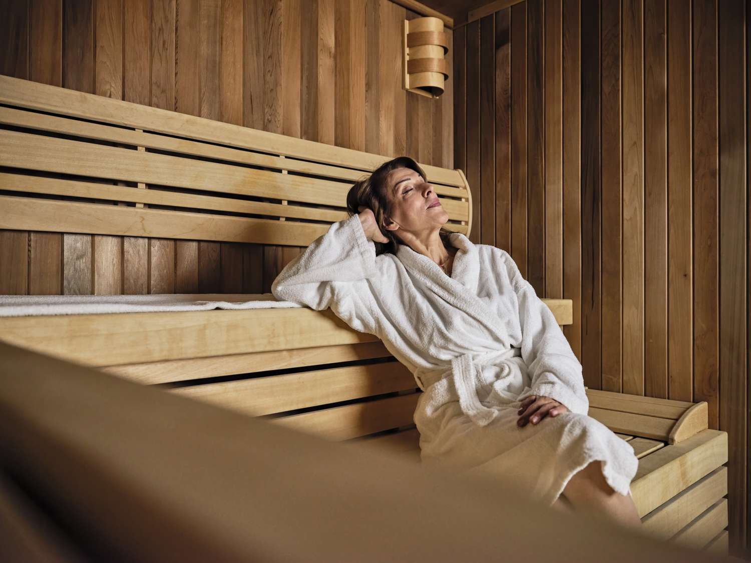 A woman in a sauna enjoying a relaxation session as part of a wellness routine.