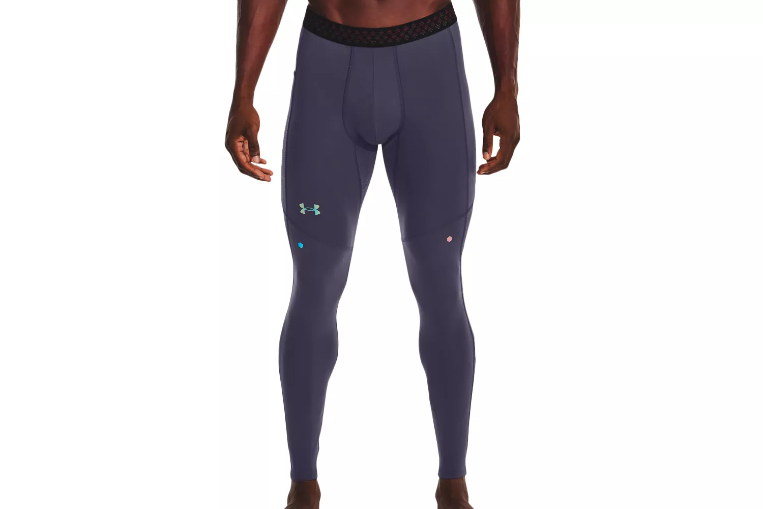 A male model wearing dark gray Under Armour compression leggings with a black mesh waistband.