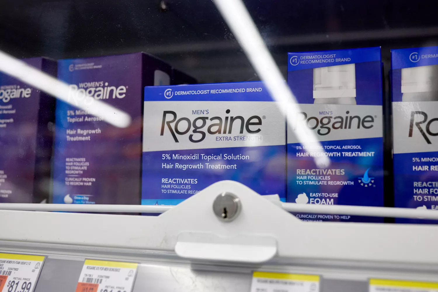 Close-up of Rogaine products on a pharmacy shelf.