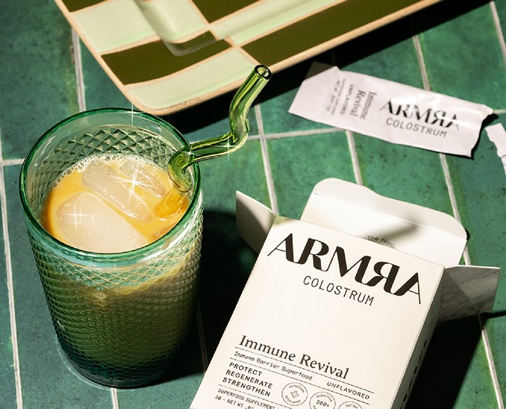Graphic with text 'Colostrum Is In' featuring ARMRA Colostrum packaging.