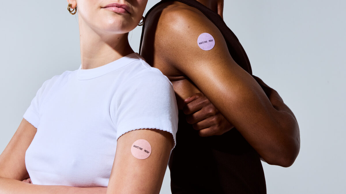 A person comfortably wearing a small wellness patch on their inner wrist.