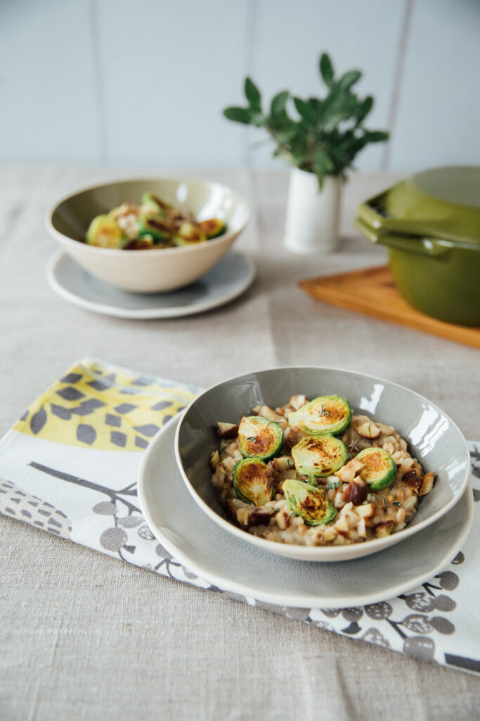 A bowl of pearled spelt risotto with chickpeas and vibrant green herbs.