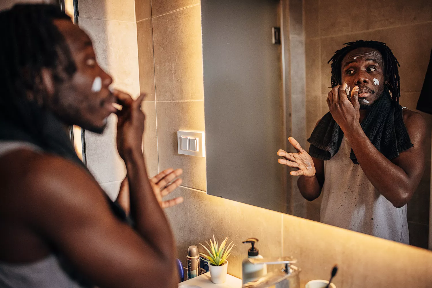An athlete checking his reflection while performing self-care maintenance.