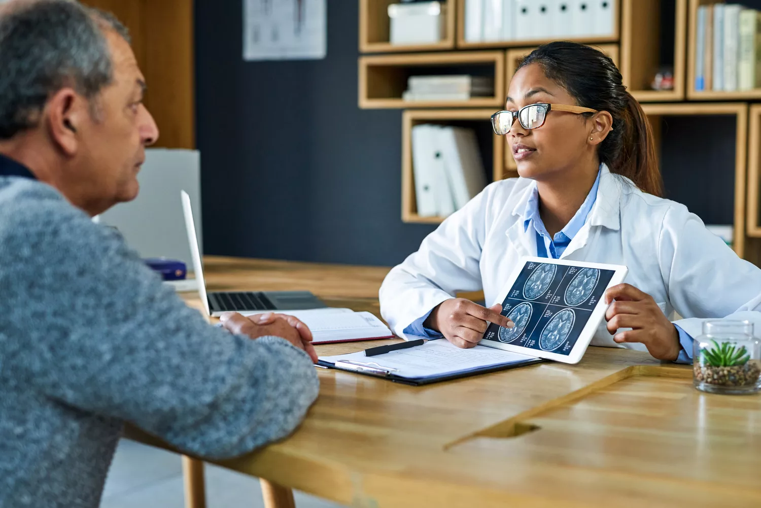 A close-up of a healthcare professional explaining MRI results to a patient to differentiate between sleep inertia and sleep disorders.