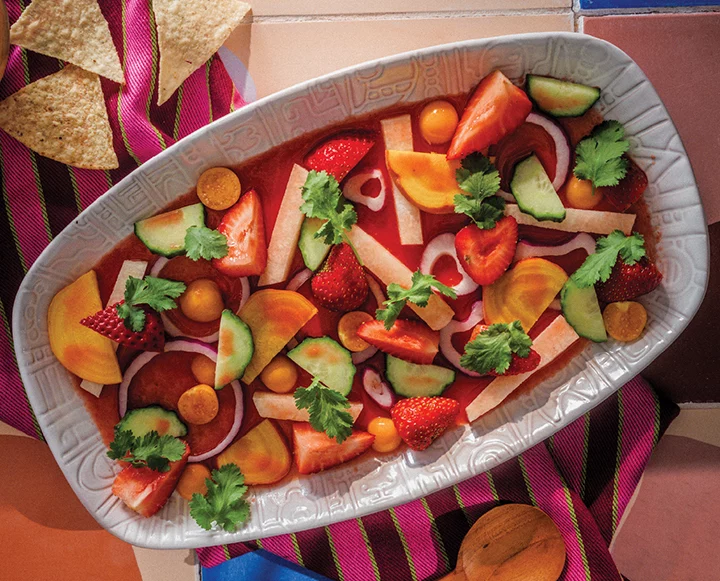 Vegetarian strawberry habanero aguachile with sliced strawberries and fresh herbs.