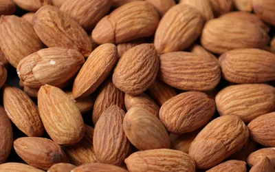 A close-up pile of raw, unprocessed almonds.