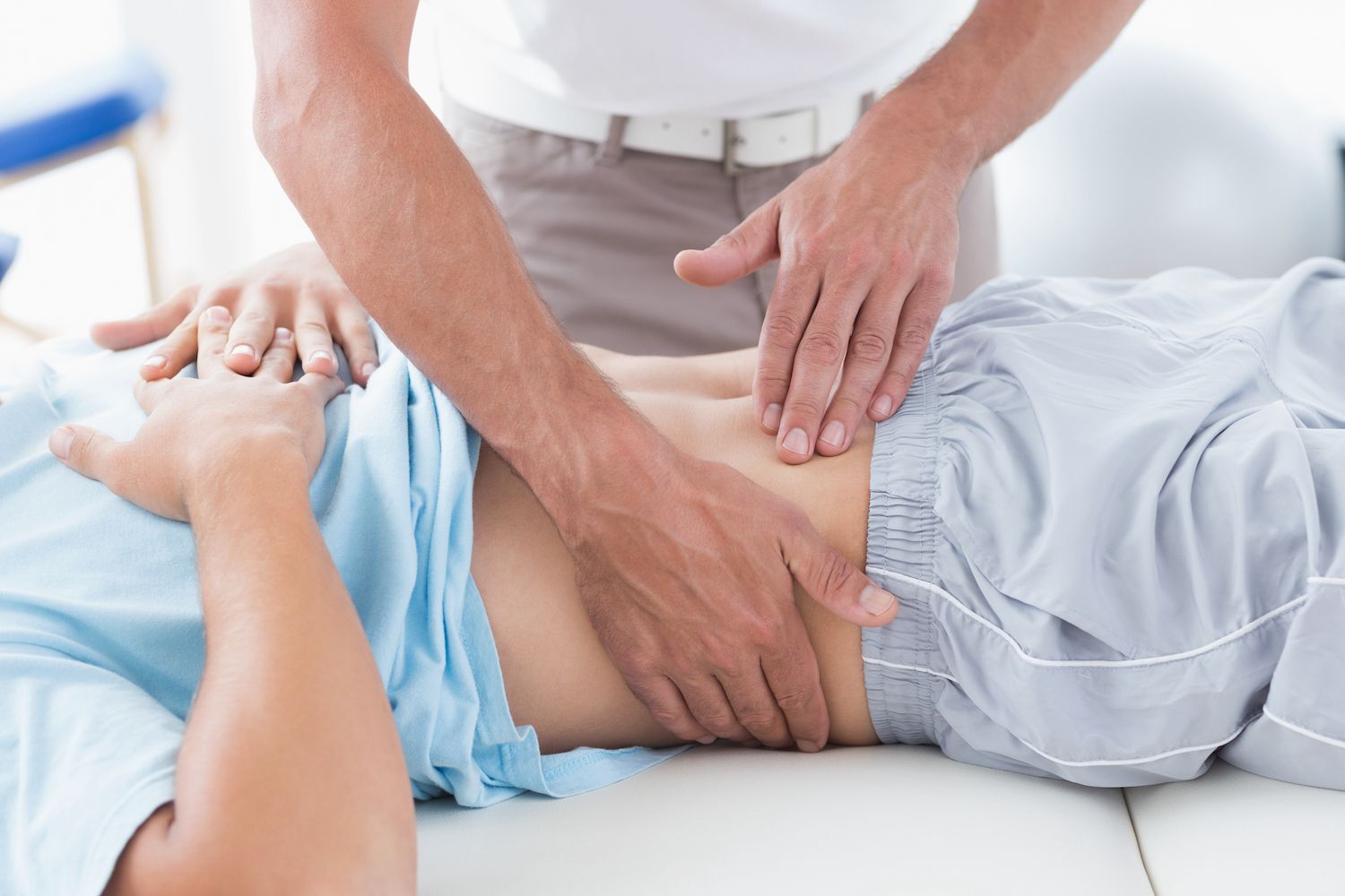 A clinical view of an abdominal ultrasound being performed by a medical professional.