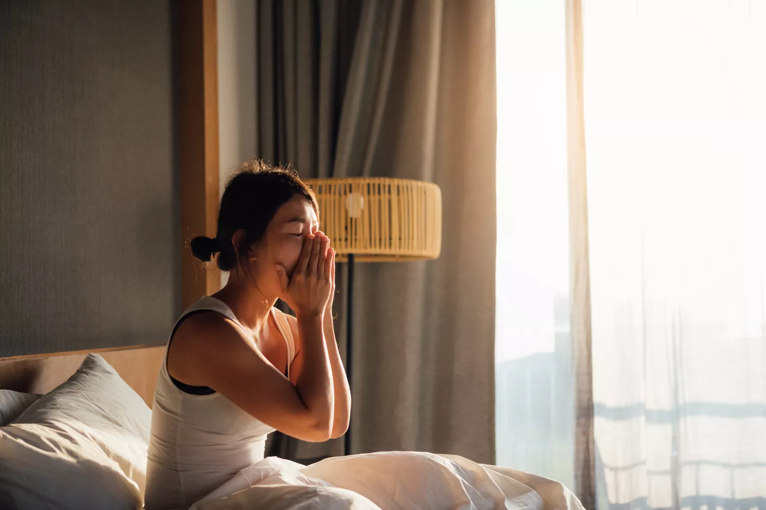 A woman yawning, illustrating the exhaustion that often accompanies chronic musculoskeletal pain and recovery.