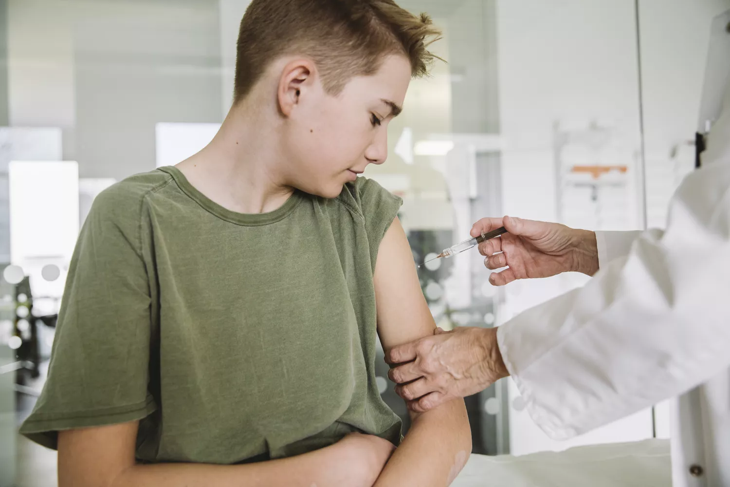 A medical professional administering a vaccination to a young patient.