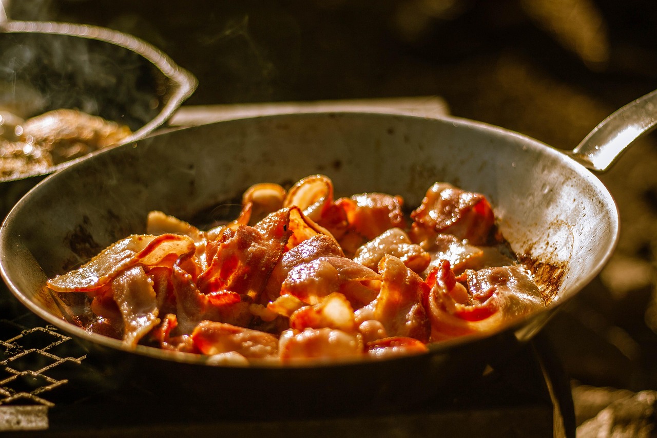 Sliced mushrooms searing in a hot cast iron skillet with visible browning.