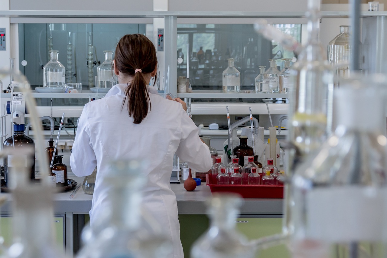 A green leaf inside a glass laboratory beaker representing clinical clean beauty
