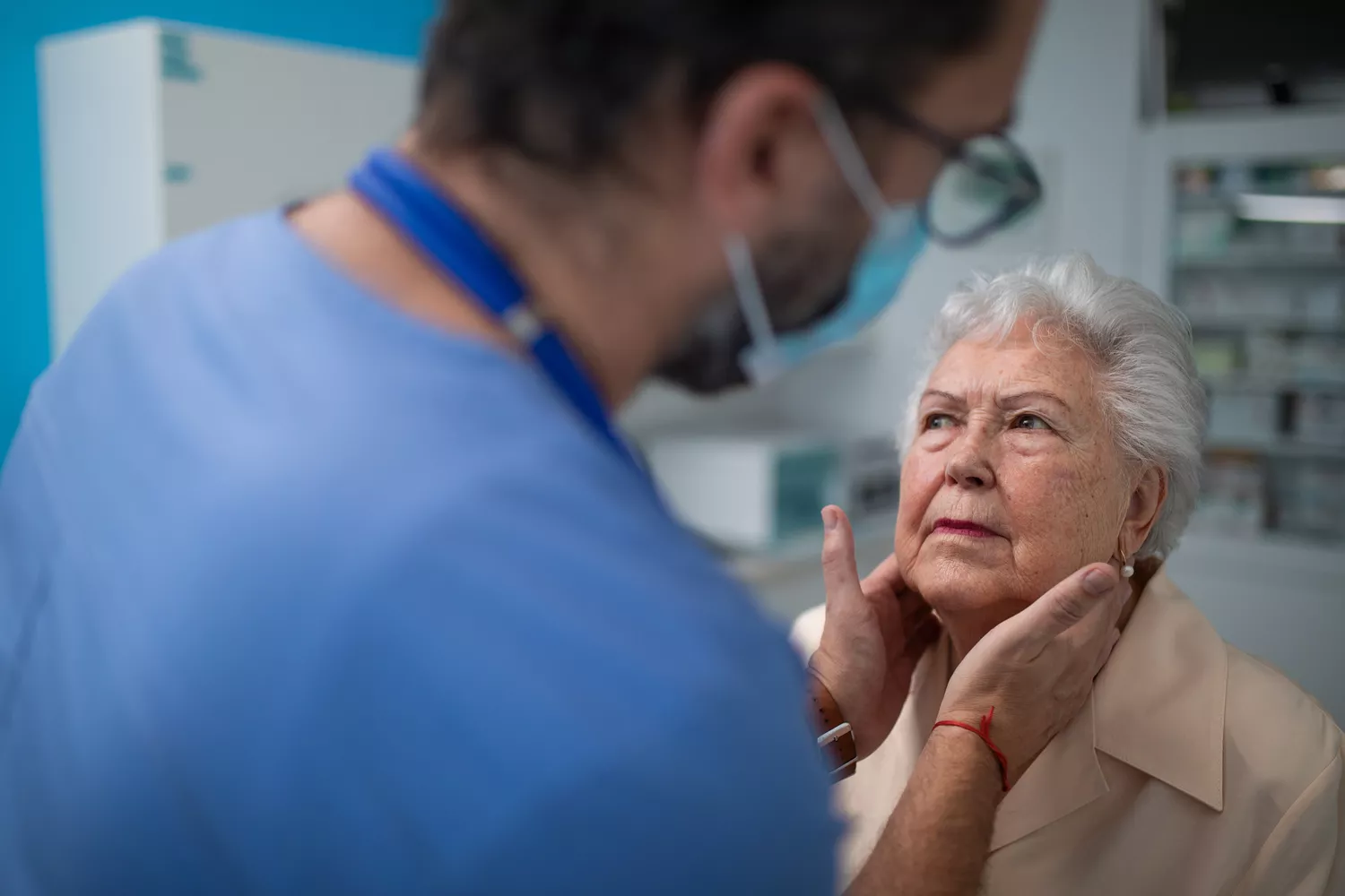 A healthcare provider palpating a patient's neck during a physical examination.