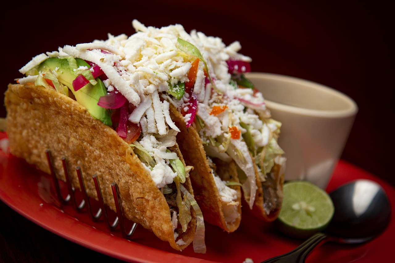 Close-up of tacos topped with finely chopped onions, radishes, and fresh cilantro.
