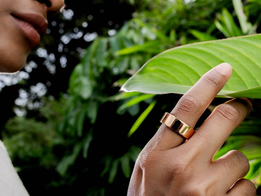A smart ring resting on its dedicated circular charging cradle.