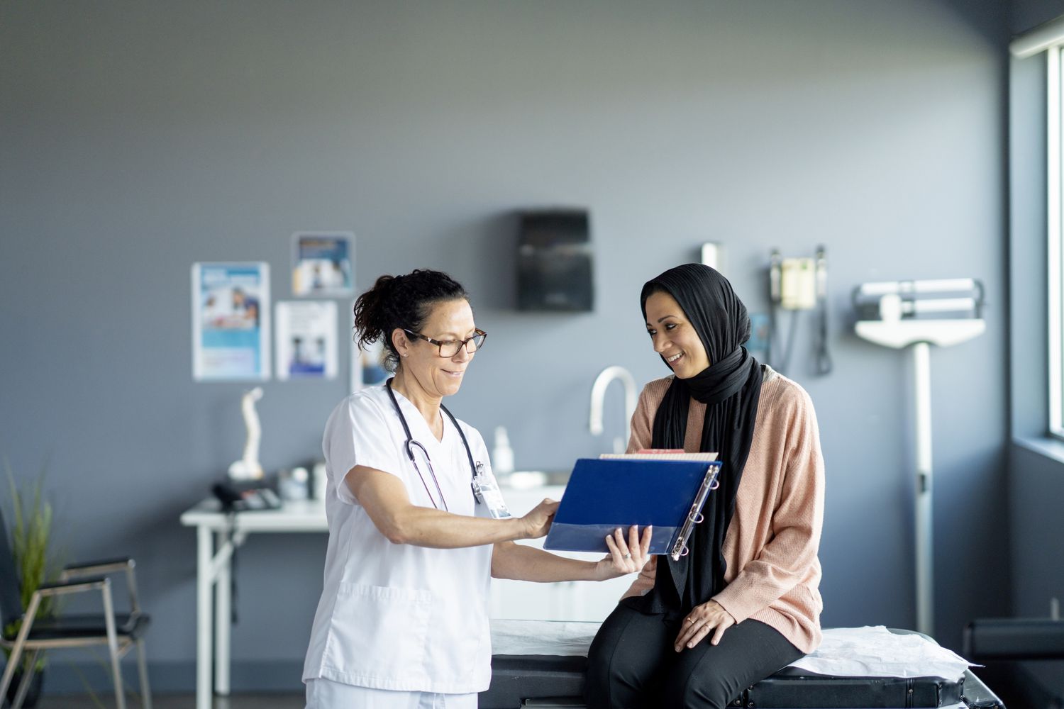 A healthcare professional and a patient reviewing biometric data in a clinical setting.