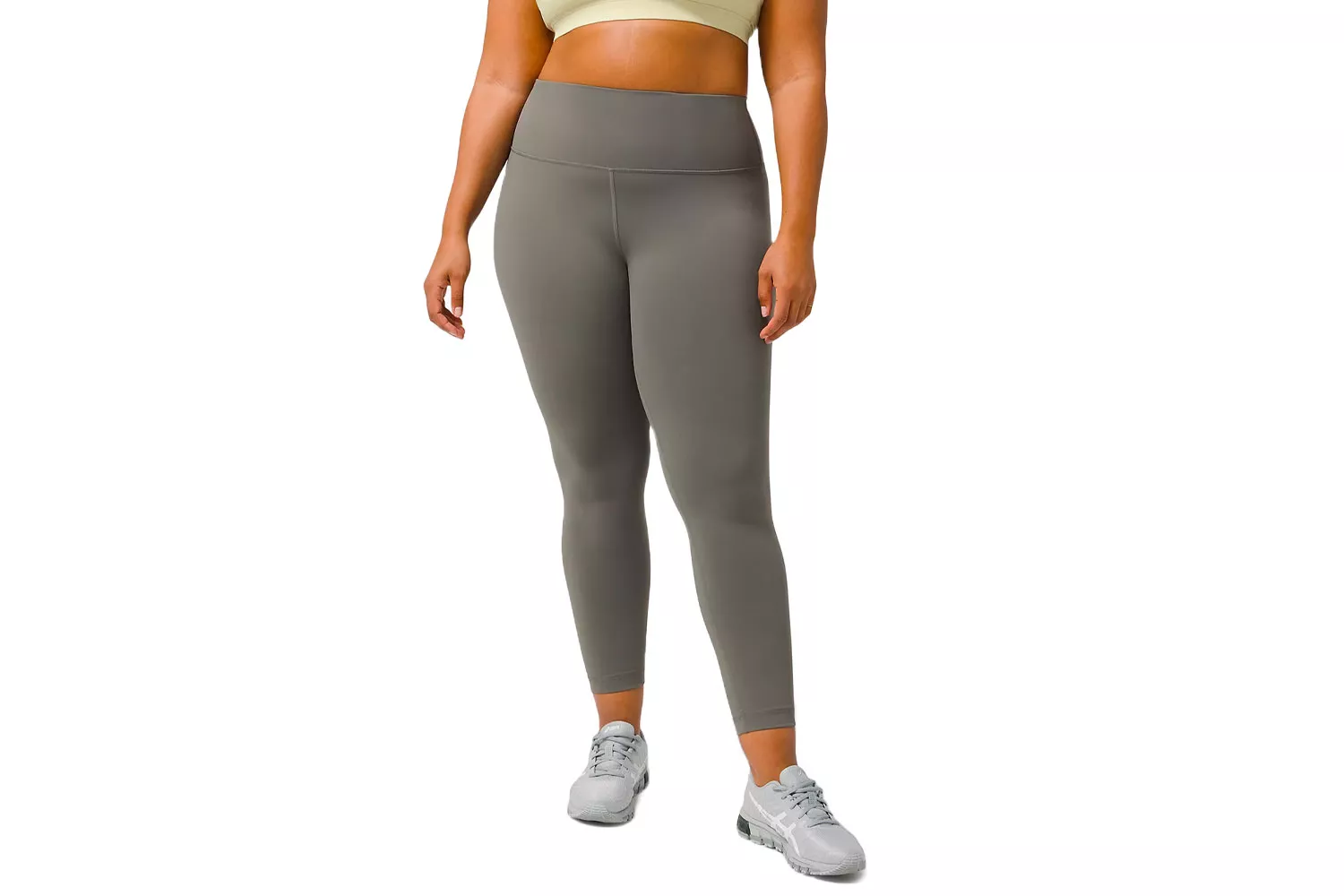 A plus-size woman modeling gray high-rise athletic leggings and a matching crop top.
