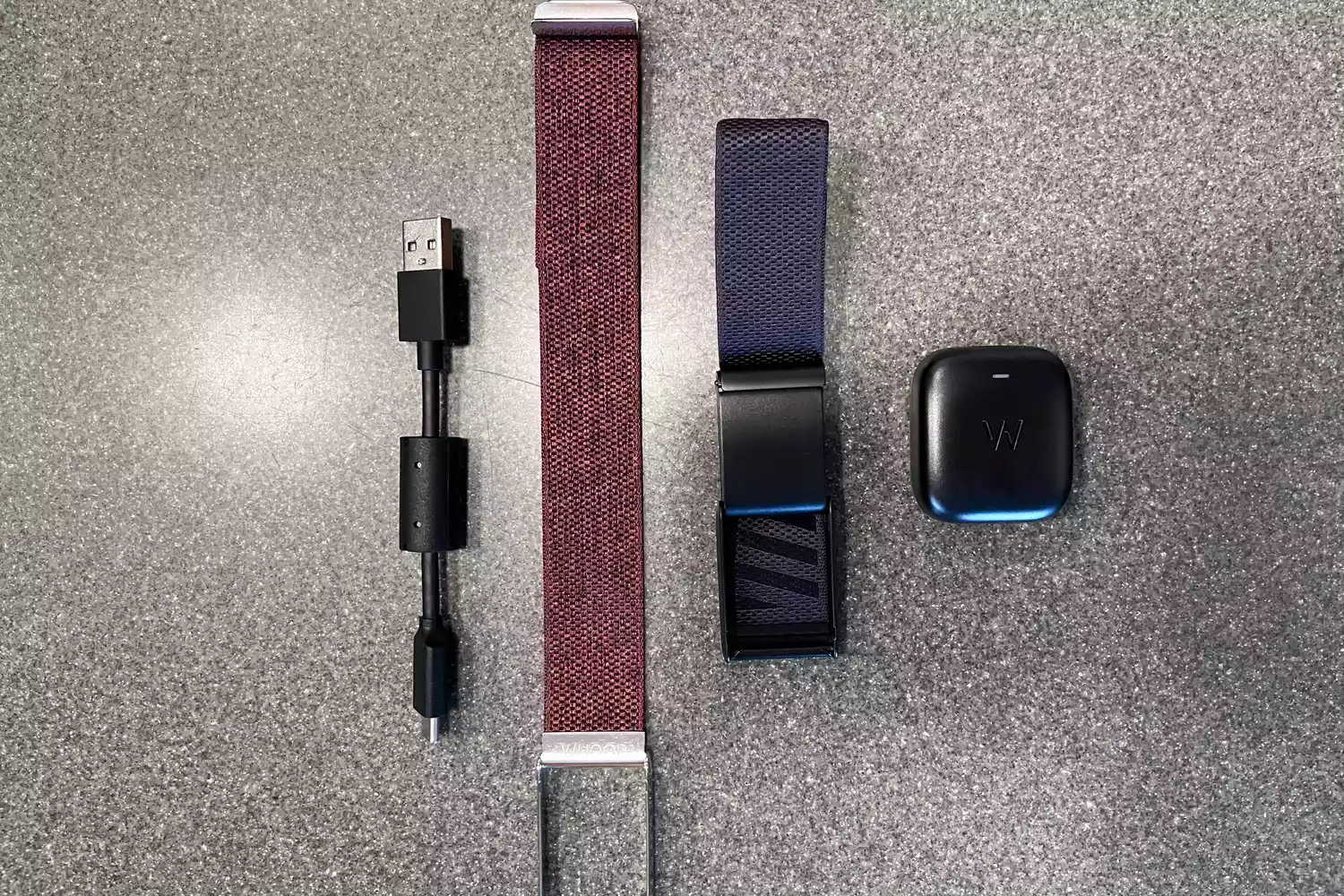 Whoop 4.0 accessories including a charging battery pack, USB-C cable, and extra bands.