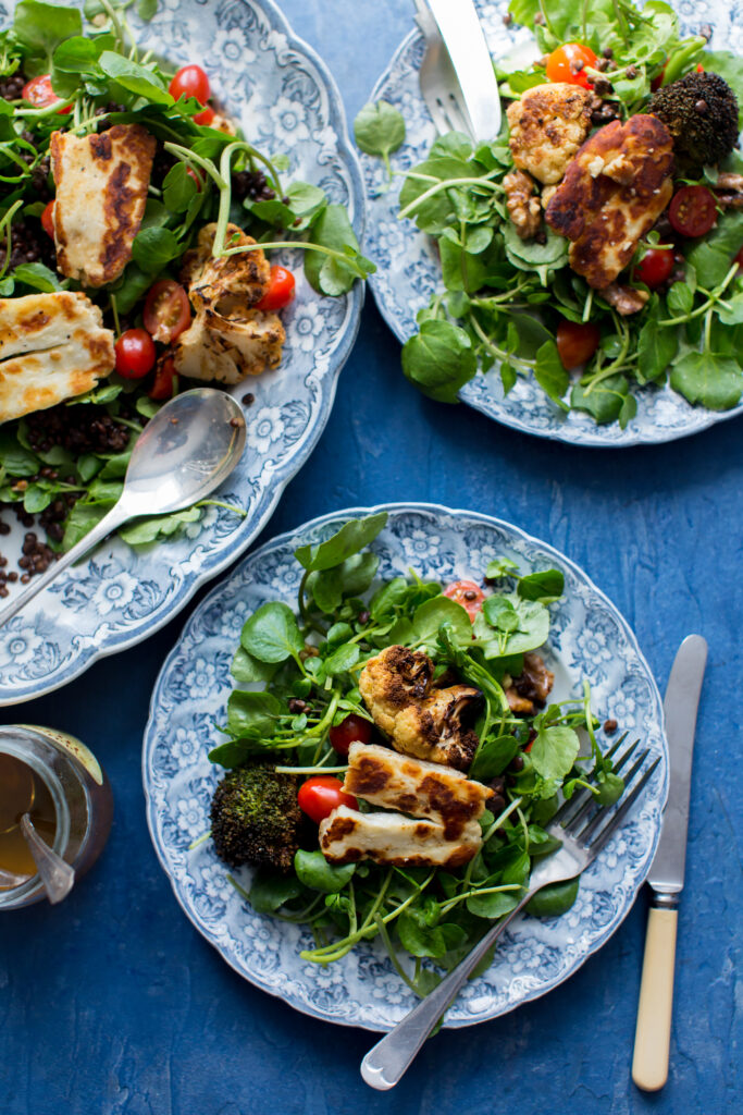 A warm salad featuring dark Puy lentils, grilled halloumi cheese, and fresh watercress sprigs.