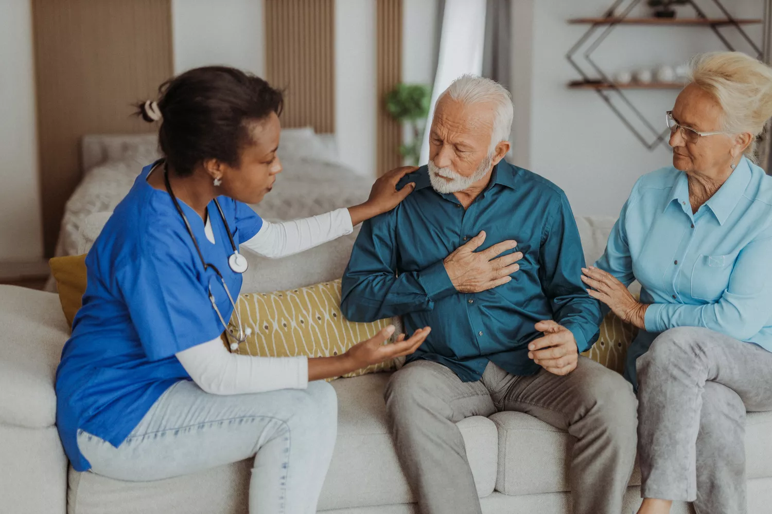 A healthcare provider offering supportive advice to a patient in a comfortable home setting.